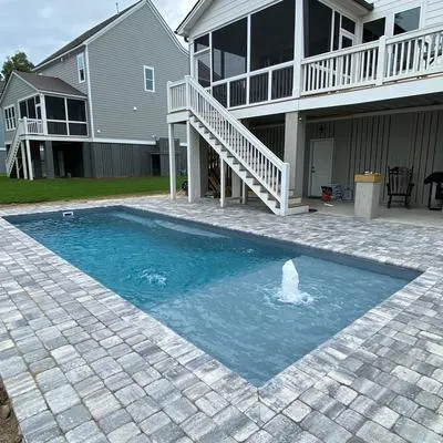 An elegant kidney-shaped pool surrounded by a lush green lawn.